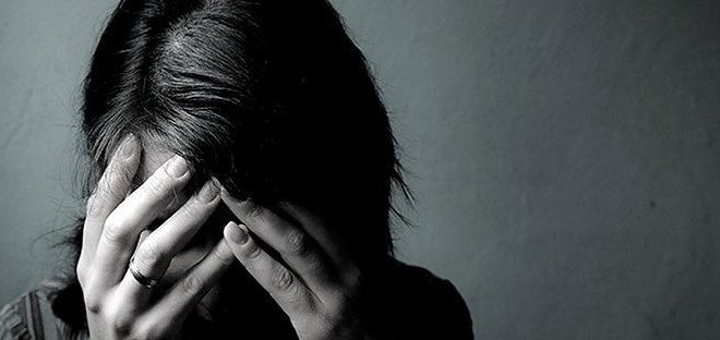 Woman in distress covering her face with her hands