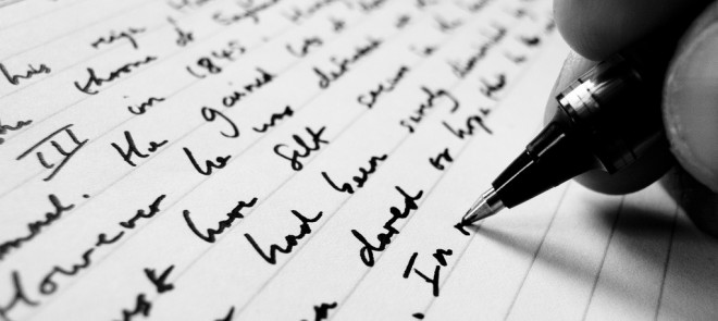 Image shows hand writing words onto a page