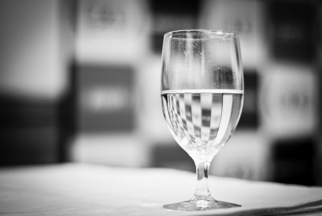 Black and white image of a glass half full with water