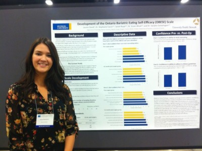 A young woman is presenting her research at a poster presentation