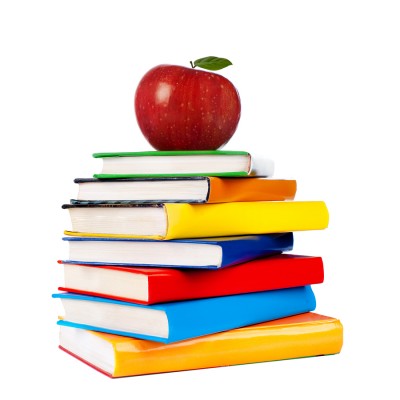 Shiny red apple on top of a pile of books